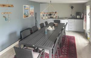 a dining room with a black table and chairs at Cozy Home In Thyborøn With Wifi in Thyborøn
