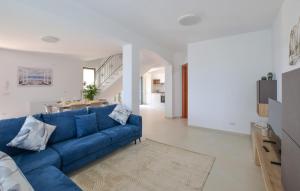 a living room with a blue couch and a kitchen at L'onda Dolce in Diamante