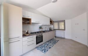 a kitchen with white cabinets and a stove top oven at L'onda Dolce in Diamante
