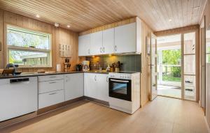 a kitchen with white cabinets and an oven at 3 Bedroom Nice Home In Farsø in Farsø