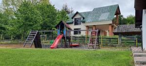 a playground in front of a house with a slide at Pensiunea BriAdda in Poiana Mărului