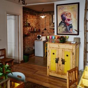 a kitchen with a wooden cabinet and a painting on the wall at Apartament Art Cluj in Cluj-Napoca