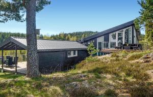 a black house with a tree in front of it at Beautiful Home In Trøgstad in Trøgstad +18 photos