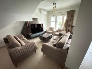 a living room with two couches and a television at Townhouse in Ras Elhekma