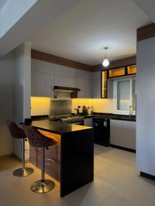 a kitchen with a stove and a counter with a stool at Townhouse in Ras Elhekma