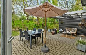 a patio with an umbrella and a table and chairs at 2 Bedroom Cozy Home In Hadsund in Hadsund