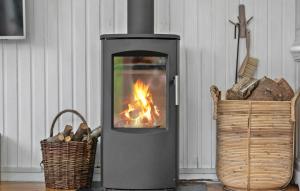 a fireplace with a fire in it next to two baskets at 2 Bedroom Cozy Home In Hadsund in Hadsund