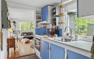 a kitchen with blue cabinets and a sink at 2 Bedroom Cozy Home In Hadsund in Hadsund