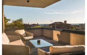 un patio avec des chaises et une table sur un balcon dans l'établissement Cozy Home In Kastelir With Sauna, à Kaštelir