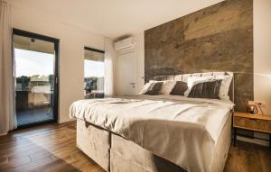 une chambre avec un grand lit avec un mur en pierre dans l'établissement Cozy Home In Kastelir With Sauna, à Kaštelir