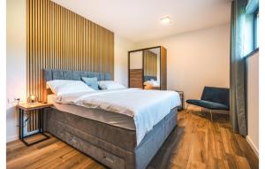 une chambre avec un grand lit et une chaise bleue dans l'établissement Cozy Home In Kastelir With Sauna, à Kaštelir