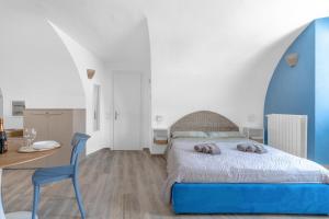a bedroom with a blue bed and a table at Kalimera alla Rocca di Manerba in Montinelle