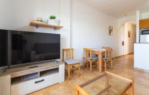 ein Wohnzimmer mit einem großen TV sowie einem Tisch und Stühlen in der Unterkunft Nice Apartment In San Pedro Del Pinatar in San Pedro del Pinatar
