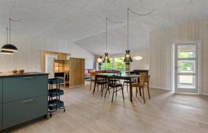 a kitchen and dining room with a table and chairs at 4 Bedroom Gorgeous Home In Oksbøl in Oksbøl