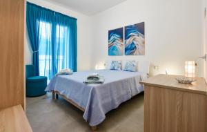 ein Schlafzimmer mit einem Bett und einem blauen Stuhl in der Unterkunft Beautiful Apartment In Balestrate in Balestrate