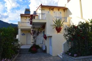 a white house with flowers on the side of it at Elli Studios & Apartments in Marathokampos