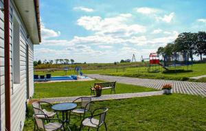 a patio with a table and chairs and a playground at Cozy Home In Sarbinowo in Sarbinowo