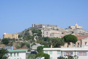 a city with a hill in the background with buildings at Gallery B&b Milazzo in Milazzo