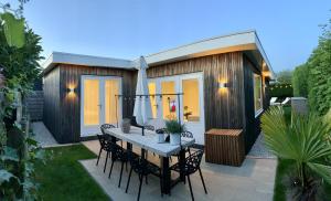 a small house with a table and chairs on a patio at Beach House nr 69, dichtbij strand Ouddorp in Ouddorp