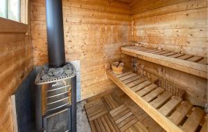 an interior of a wooden cabin with a stove at 1 Bedroom Amazing Home In Mörlunda in Mörlunda