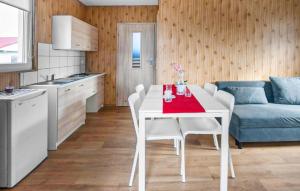 a white table and chairs in a kitchen with a couch at Awesome Home In Sarbinowo in Sarbinowo