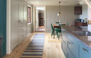 a kitchen with blue cabinets and a table with chairs at 1 Bedroom Amazing Home In Mörlunda in Mörlunda +7 photos