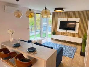 凯斯特海伊GADA Apartman的带桌椅和电视的客厅