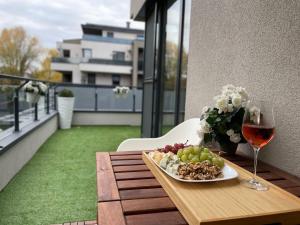 a table with a plate of food and a glass of wine at GADA Apartman in Keszthely
