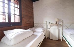 two beds in a room with a window at Ferienhaus Bad Kleinkirchheim in Bad Kleinkirchheim +2 photos
