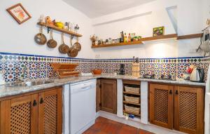 a kitchen with wooden cabinets and tiles on the wall at Cómpeta in Cómpeta