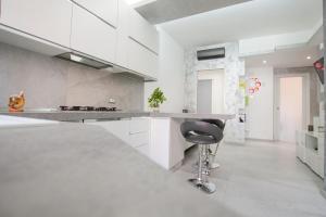 a kitchen with white cabinets and a black stool at Casa Potos - M1 - San Siro - Rho Fiera in Milan