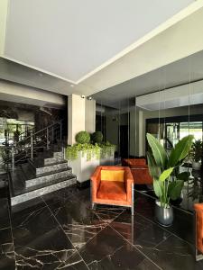 a lobby with a staircase and orange chairs at SA Apartments! 150m to the Cleopatra Beach in Alanya