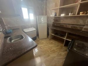 a small kitchen with a sink and a refrigerator at شقق فندقيه مكيفه برج العرب الجديده in Borg El Arab