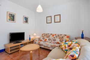 a living room with a couch and a tv at Villa Camaleón in Chiclana de la Frontera