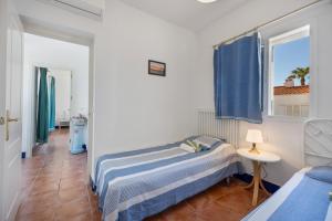 a small bedroom with a bed and a window at Villa Camaleón in Chiclana de la Frontera +28 photos