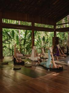 a group of people doing yoga in a room at Grün Resort Uluwatu in Uluwatu