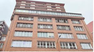 a tall red brick building with many windows at Apartamentos Olivia by gaiarooms in Bilbao