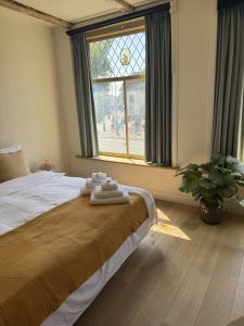 Un dormitorio con una cama grande con ventana. en The Hazel House, en Haarlem