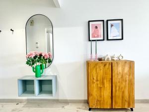 a mirror and a vase with flowers on a table at Atreb San Fernando in San Fernando +2 photos