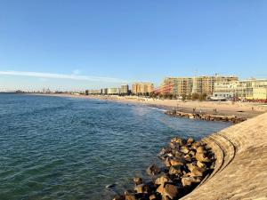 a beach with a bunch of rocks in the water at SunHouse Alojamentos in Senhora da Hora