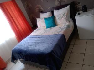 a bedroom with a bed with a blue comforter at Nala Guesthouse in Ellisras