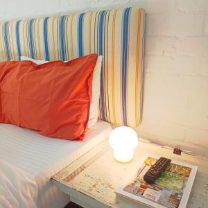 a bed with a pillow and a remote control on a table at The Retreat in Kommetjie