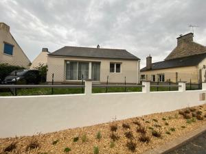 a white fence in front of a house at La petite maison du FA in Hillion