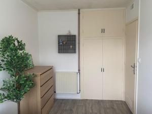 a room with two white cabinets and a potted plant at La petite maison du FA in Hillion +1 photo