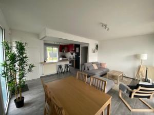 a living room with a table and a living room with a couch at La petite maison du FA in Hillion