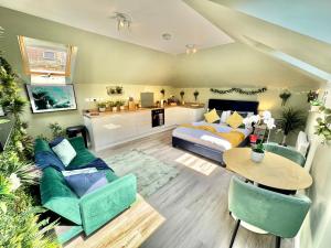 a living room with a bed and a table at Luxe Chic Retreat - Tropical Vibes & Skylight Serenity - WiFi - Large Smart TV - Minutes Walk to Town and Beach - Sleeps 3 in Bournemouth