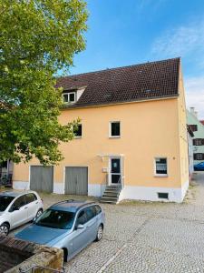 dos autos estacionados frente a una casa en Haus Leipheim, en Leipheim