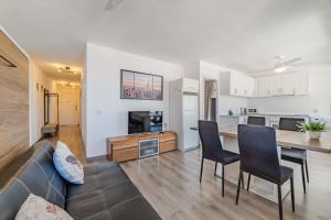 ein Wohnzimmer mit einer Couch und einem Tisch mit Stühlen in der Unterkunft Family flat with 3 bedrooms and balcony near Los Gigantes and ocean in Puerto de Santiago