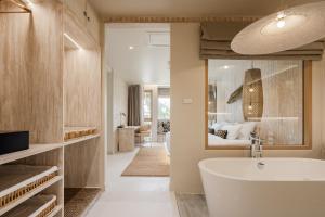 ein Bad mit einer Badewanne und ein Schlafzimmer in der Unterkunft Phangan Bayshore Resort Koh Phangan in Haad Rin