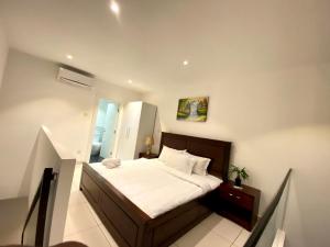 une chambre avec un grand lit avec des draps blancs dans l'établissement Prime Suites at Embassy Gardens, à Accra 24 autres photos